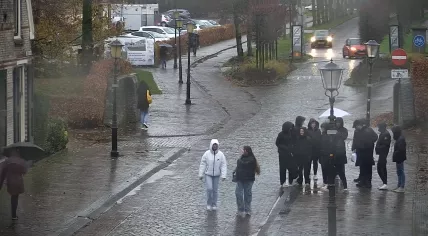 People on the street in Elburg, Gelderland, as rain showers pass by with a stiff wind. 27 Nov. 2024