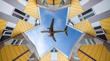 Airplane flying above houses.
