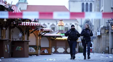 Police officers patrol a cordoned-off area at a Christmas Market, where a car drove into a crowd on Friday evening, in Magdeburg, Germany, Saturday, Dec. 21, 2024