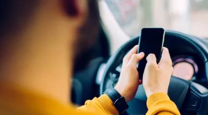 A man is using his phone behind the wheel
