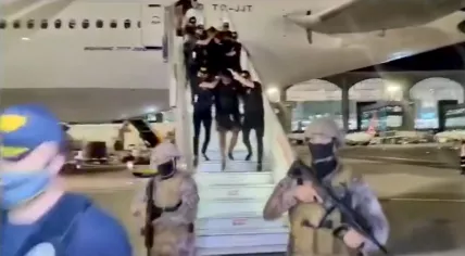 Isaac B. led off an airplane by police in Turkey. July 2023