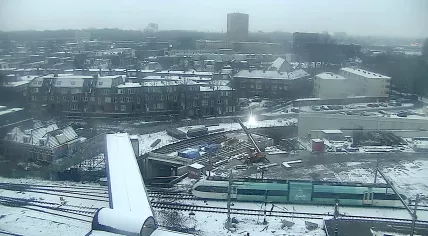 An Arriva train passes by the Groningen Station while construction workers carry out renovation work in the cold and snow. 13 February 2025