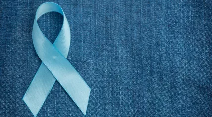 Blue ribbon for prostate cancer awareness on a demin background