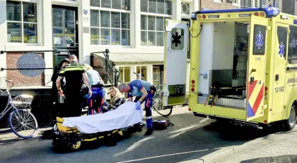 A victim of a stabbing with multiple injuries at Dam Square is helped by ambulance workers.