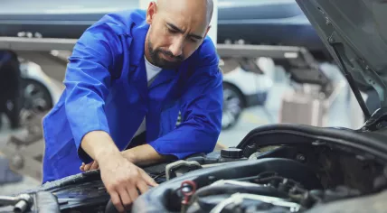 A mechanic fixing a car in a service garage