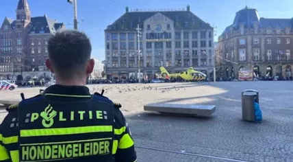 A police officer looks on as a trauma helicopter arrives in Amsterdam after five people were stabbed in the city center. 27 March 2025