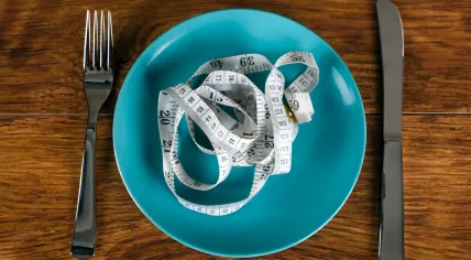 Weight loss concept - tape measure on an empty plate