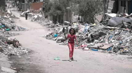 A child walks throuhg rubble in Gaza on her way to get food, 25 August 2024