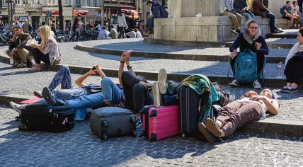 Tourists in Amsterdam laying down on Dam Square while using their smartphones. 9 Sept. 2015