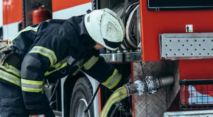 A firefighter prepares a hose.