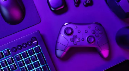 Blue lit keyboard amidst various modern gaming devices