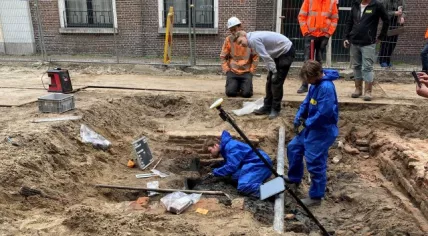 IDDS archaeologists excavate an earthenware pot that was buried under a floor.
