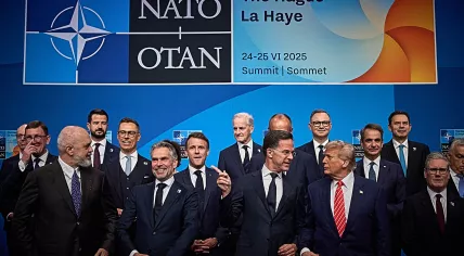 NATO Secretary General Mark Rutte pointing past a grinning Dutch Prime Minister Dick Schoof while speaking with U.S. President Donald Trump at the start of the NATO Summit in The Hague. 24 June 2025