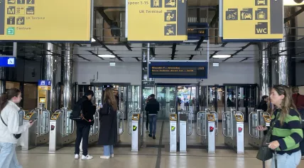 Travelers walk through the access gates in the newly reopened western passenger tunnel on the city center side of Amsterdam Centraal Station, June 2, 2025.
