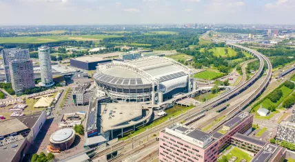An aerial view over the Johan Cruijff ArenA and ING’s Amsterdam-Zuidoost headquarters, looking towards the Strandvliet metro stop, and Duivendrecht in Ouder-Amstel.