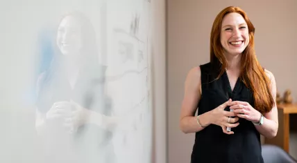 A woman leading a business analysis and consulting presentation in July 2019
