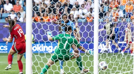 Ella Powell (Wales), Esmee Brugts (Netherlands) scores to make it 0–3, and Wales goalkeeper Olivia Clark during the Euro Group D match between Wales and the Netherlands at the Allmend Stadium in Switzerland.