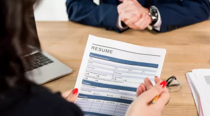 A recruiter holding a candidate's resumé 