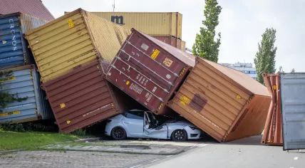 At Eemhavenweg in the Port of Rotterdam, strong gusts of wind caused several shipping containers to topple onto four vehicles.