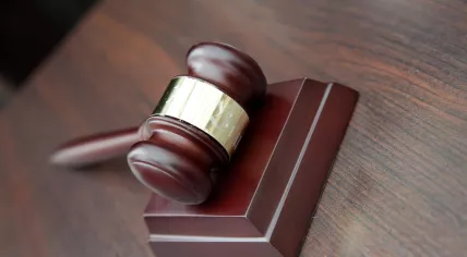 A gavel rests on the desktop of a judge's bench. 