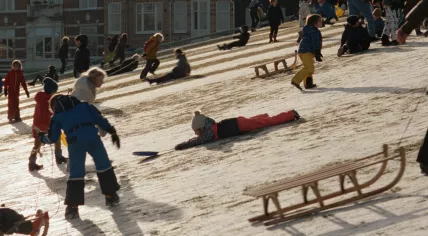 A still image of children playing in the snow in Amsterdam from director Steve McQueen's documentary, Occupied City