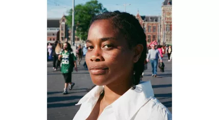 South African poet Julia-Beth Harris standing in front of Amsterdam Centraal Station in 2025
