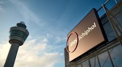 Angled shot showing Amsterdam Airport Schiphol's logo and an air traffic control tower