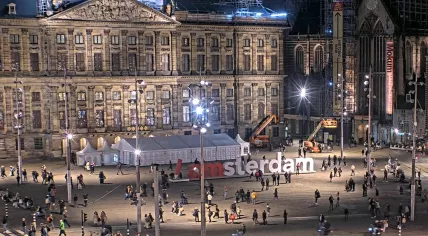 People pose in front of the “I Amsterdam” sign placed at Dam Square in front of a special polling place set up for the Tweede Kamer election outside of the Royal Palace. The “I” was replaced by a statue of the red pencil voters are given when to mark their ballots. 29 October 2025