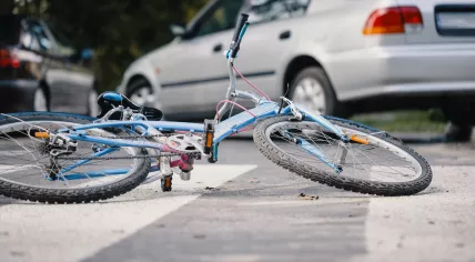 Broken bike, a car after a collision.