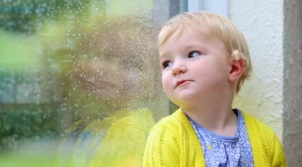 A little girl is waiting for the rain to end