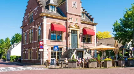 People on outdoor terrace of cafe in old town hall of Laren, Noord-Holland
