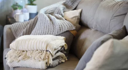 Pillows and blankets stacked on a couch