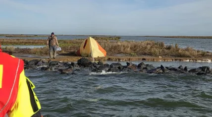 Man next to his self-built tent after spending two days on an uninhabited island on the IJsselmeer.