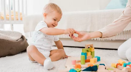 A toddler is playing with cubes