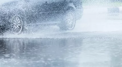 Car rides through a big puddle