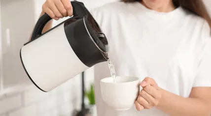 A woman pours boiled water into a mug