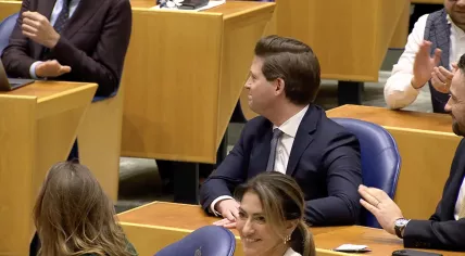 Thom van Campen (VVD) behind his smiling party leader, Dilan Yesilgöz, after his election as the new Chair of the Tweede Kamer. 18 Nov. 2025