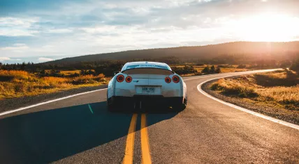 On the road in a silver Nissan GT-R sports coupé. 2019