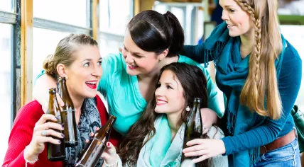 Girlfriends drinking beer on a party bus