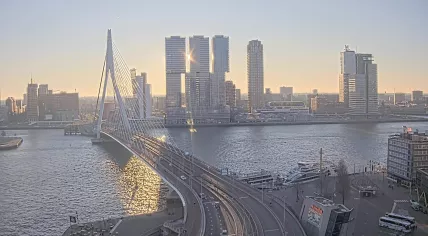 The sun rises behind De Rotterdammer complex and the Erasmus Bridge on a crisp, clear day in Rotterdam. 24 Dec. 2025