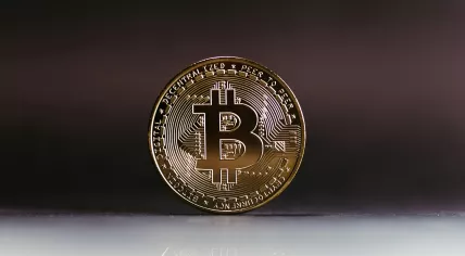 A physical bitcoin standing upright on a table