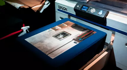 A close-up image of a high quality printed photograph in front of a commercial Epson SureColor printer