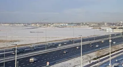 Cars drive past Schiphol Airport in the afternoon, while dozens of aircraft remained on the ground after a snowstorm passed the area. 5 Jan. 2026