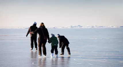 A family skates on natural ice