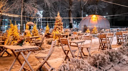 Snow-covered empty outdoor seating at a closed restaurant