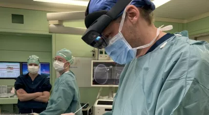 An Amsterdam UMC neurosurgeon using HoloScene mixed reality glasses to project a hologram of the brain onto a patient's head during brain surgery, January 2027