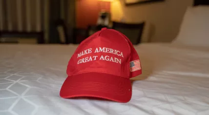A MAGA campaign hat on a hotel bed 