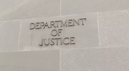 Closeup of sign of US Department of Justice (DOJ) at facade of Robert F. Kennedy Building