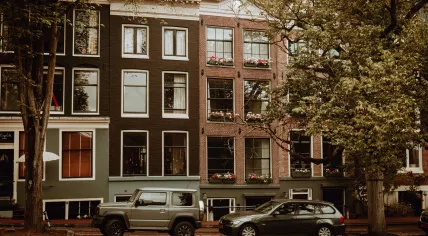 Dark SUV and a BMW wagon parked canal-side on the Reguliersgracht in Amsterdam Centrum. Aug. 2021