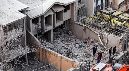 Residential buildings damaged after an airstrike, with emergency responders at the scene in Hamedan, Iran, March. 3, 2026